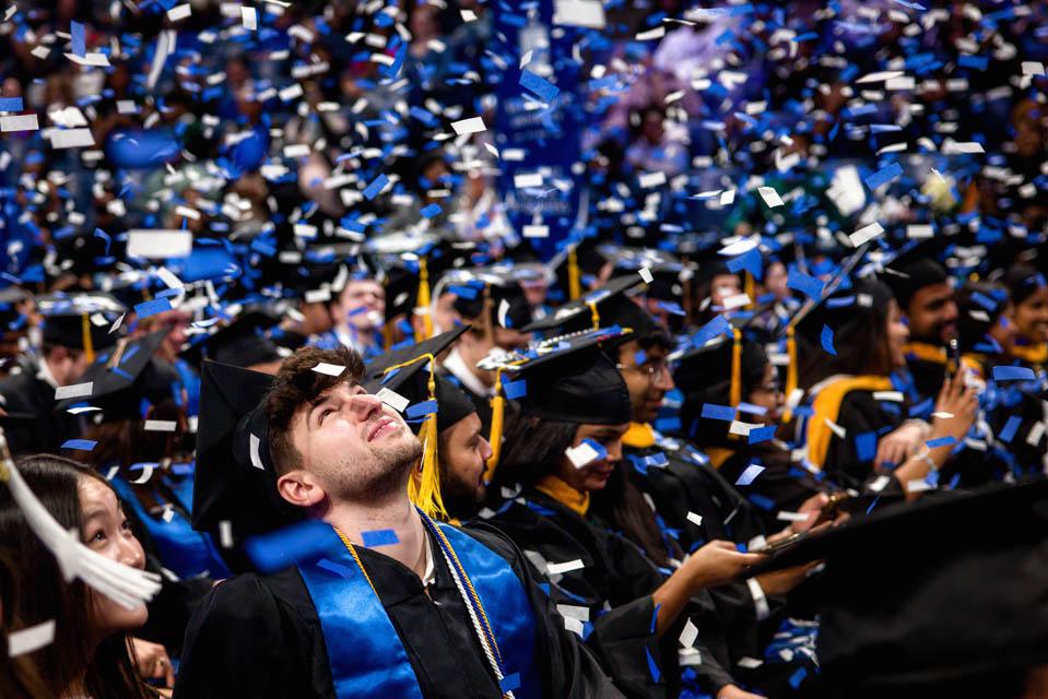 Graduates watch confetti fall during the Midyear Commencement on Saturday, Dec. 14, 2024. Photo by Sarah Conroy.  