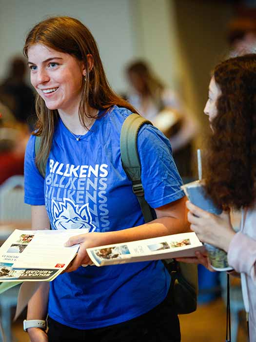 Student smiling while having a conversation with other students