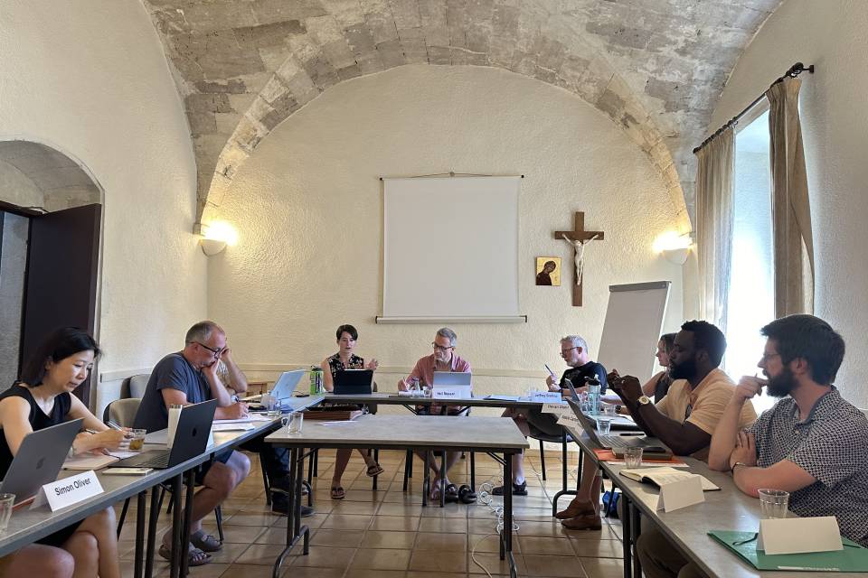 Group of faculty sit around the table during a conference.