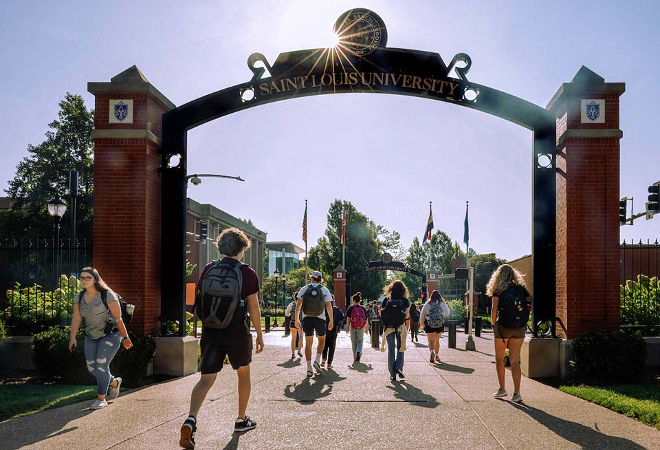 Students walk under the Saint Louis University archway on campus on the first day of classes.