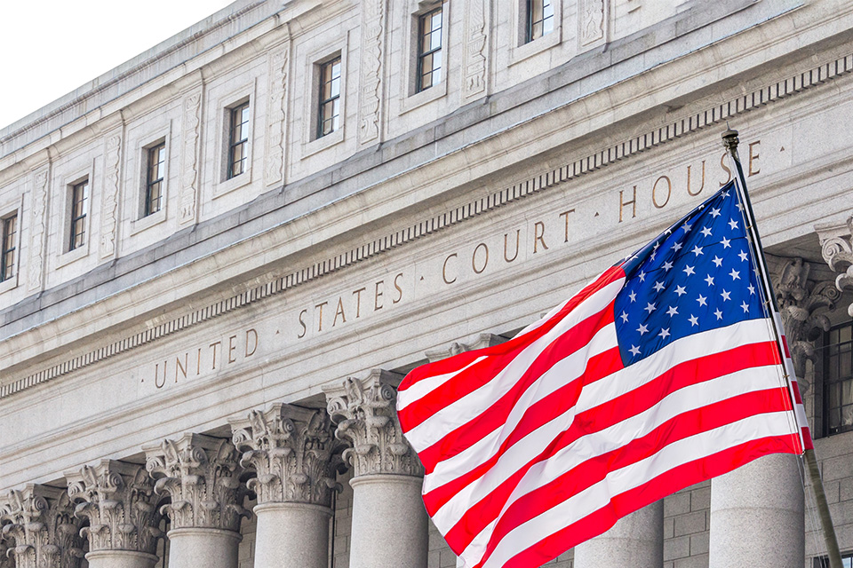 Photo of the United States Supreme Court building with a flag waving in front of it