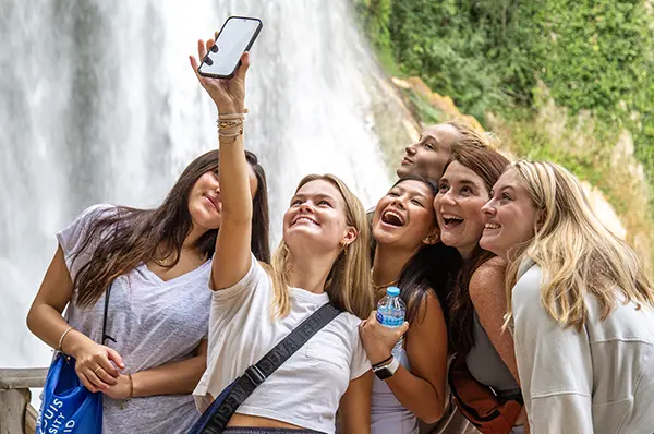 SLU students take a selfie together with a waterfall in the background.