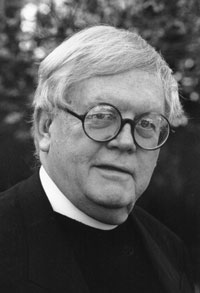 Rev. Ralph Peterson wears black clerical garb with a white collar