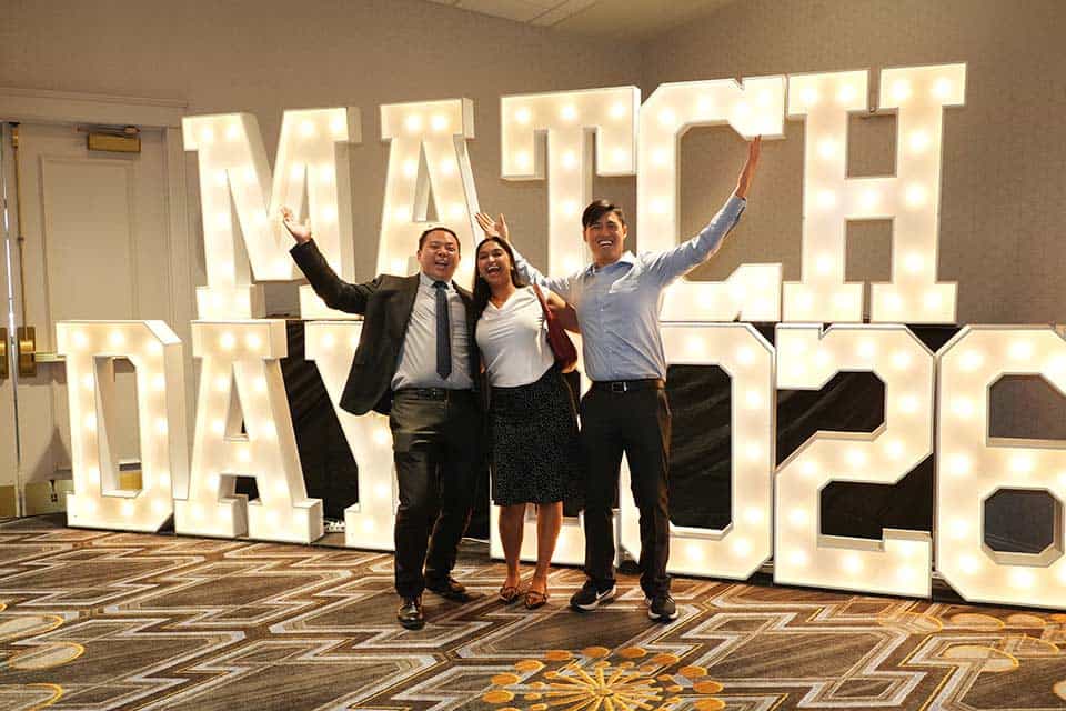 Match Day 2026 SLU medical students celebrate in front of a "Match Day 2026" illuminated sign