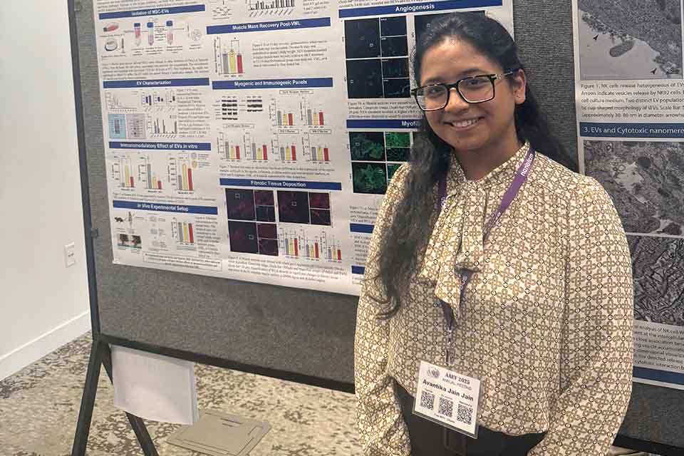 a woman stands in front of a poster