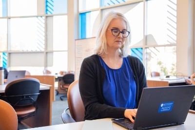 student studying at laptop in classroom